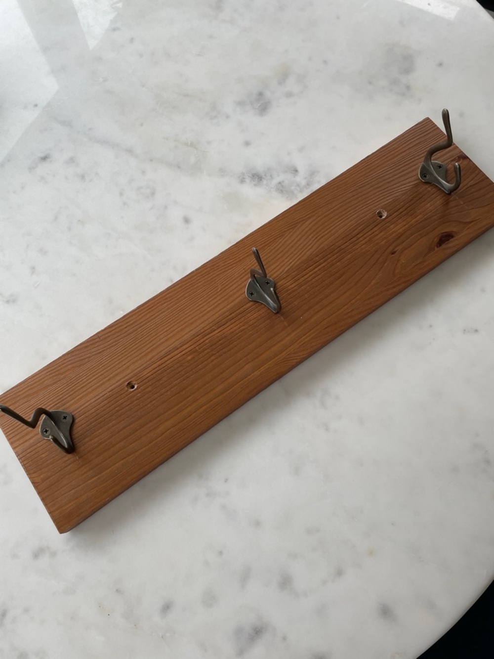 Three wall hooks mounted on wood